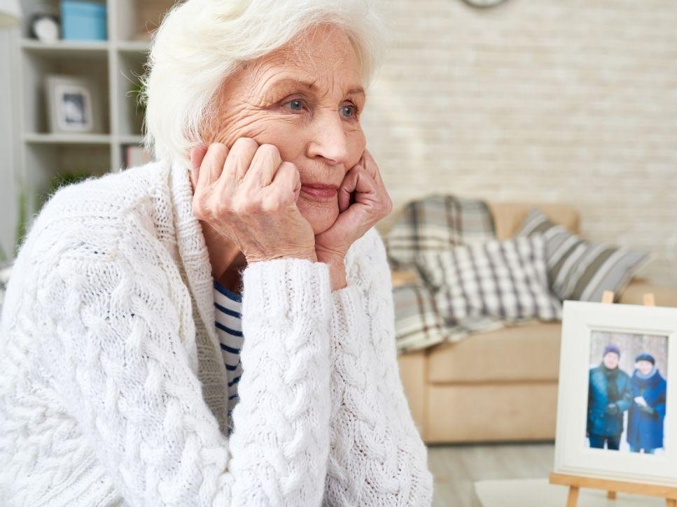 Older adult living alone at home sitting in her living room