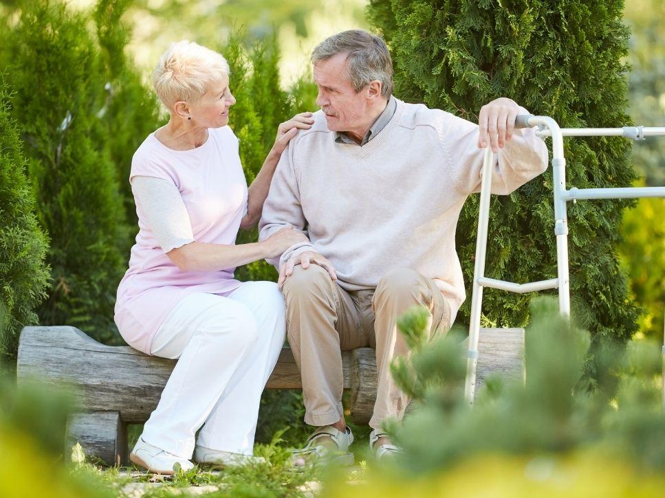 Older adult using a walker with support from a caregiver