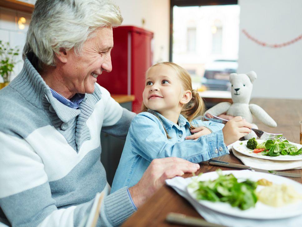 Senior resident sharing a meal with a young child in a retirement residence