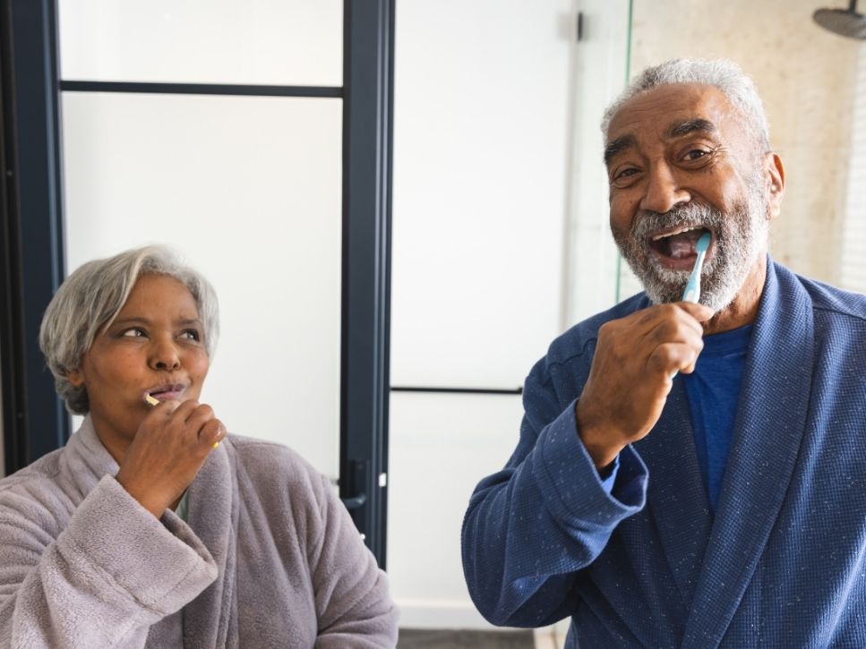 Older couple brushing their teeth together in the bathroom